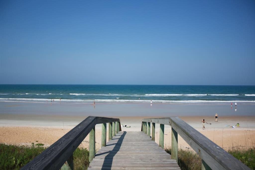 a wooden boardwalk leading to a beach with people on it at Beach, Oceanfront, Flagler Beach Rental in Flagler Beach
