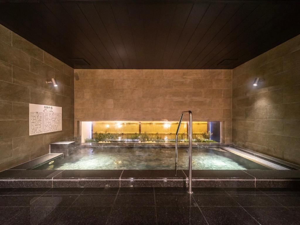 una gran piscina en un edificio por la noche en Super Hotel Yamaguchi Yuda Onsen en Yamaguchi