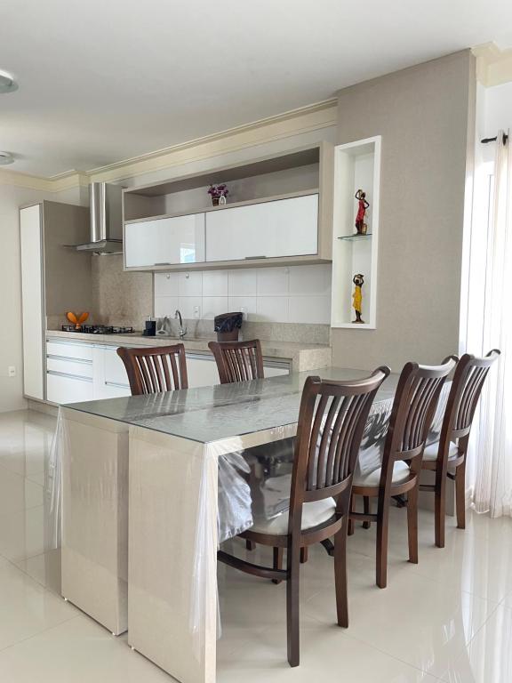 Una cocina con una gran mesa de mármol y sillas. en Apartamento com vista mar, en Porto Belo