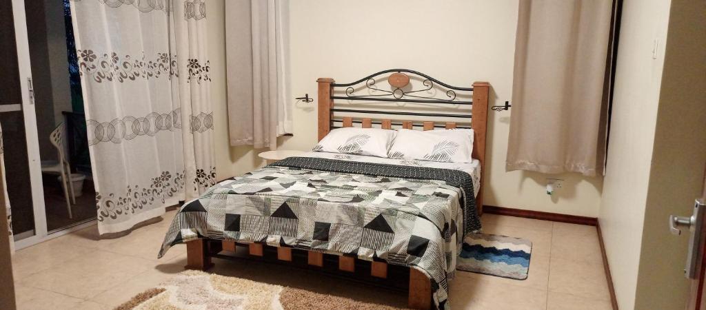 una camera con letto e testiera in legno di Peninsula drive lake side apartments a Kampala