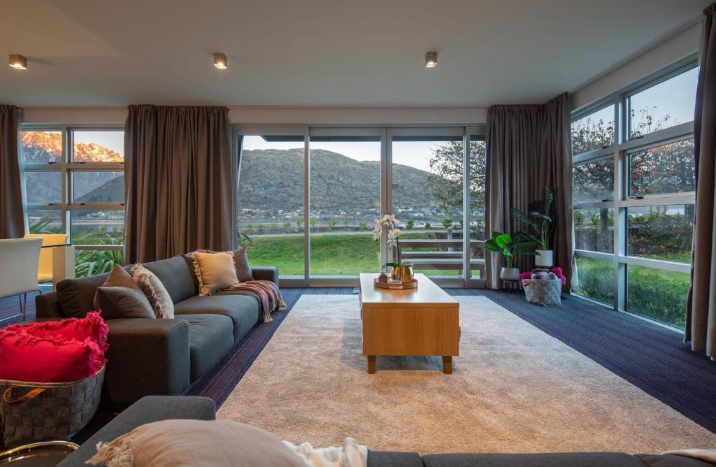 salon z kanapą i stołem w obiekcie Villa Mantra- Free Parking- AC- Direct Lake Access w mieście Queenstown