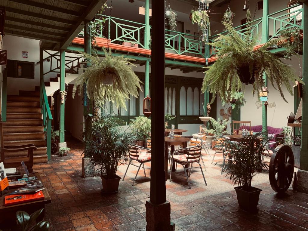 a patio with tables and chairs and potted plants at Hotel Posada de San Agustin in Tunja