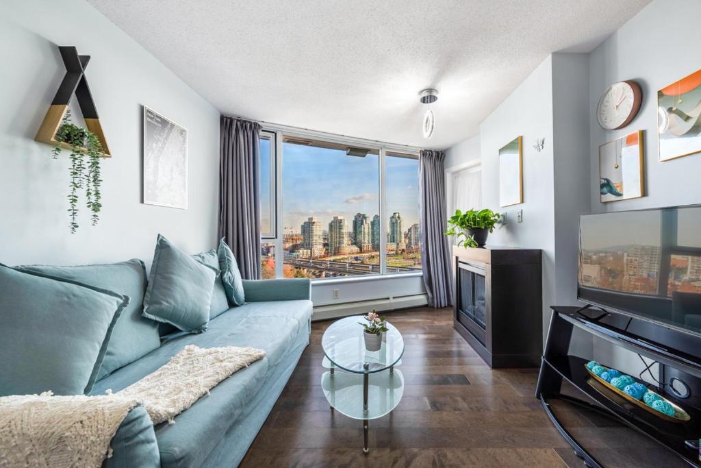 uma sala de estar com um sofá e uma grande janela em Downtown 1 Bedroom Water View Condo em Vancouver