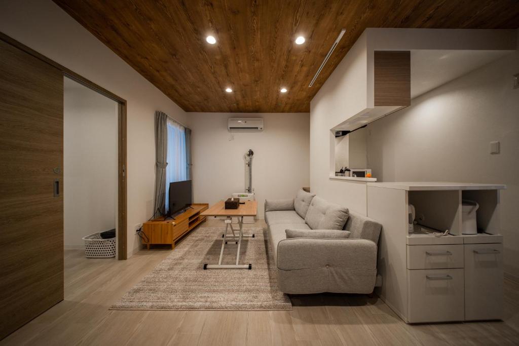 a living room with a couch and a table at ASTRAL【2min from Asahikawa sta】 in Asahikawa