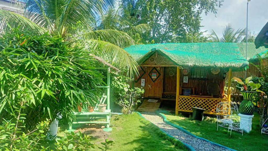 a small house with a blue roof in a garden at Moalboal Bamboo House / Rooms in Moalboal