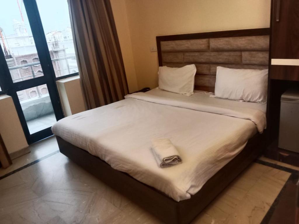 a hotel room with a bed with a towel on it at HOTEL MERCURY 50 STEP FROM DARBAR SAHIB in Amritsar