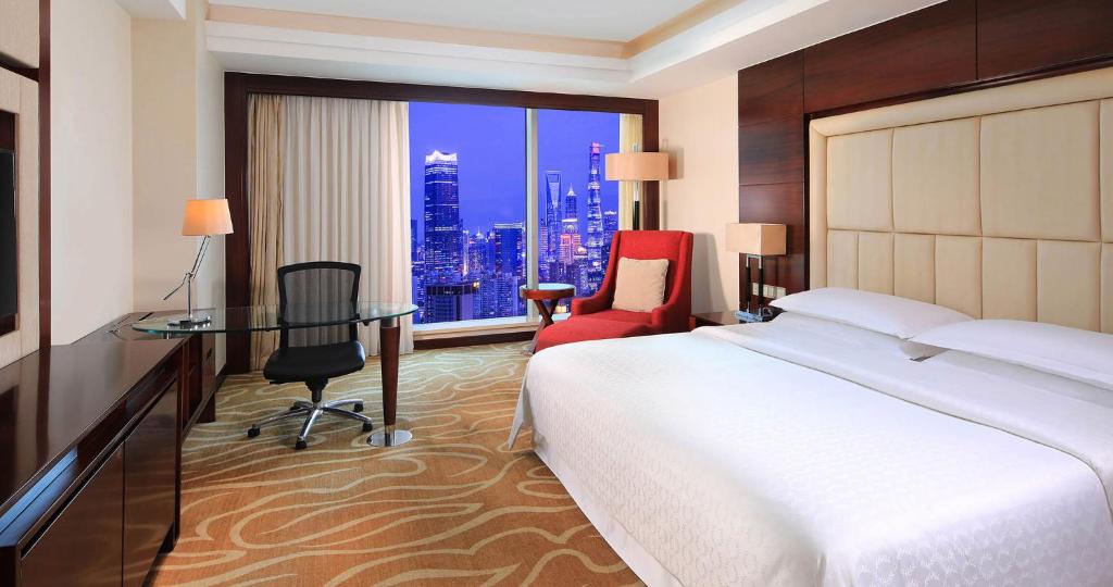 a hotel room with a bed and a desk and a window at Shanghai Hongkou Sanzhi International Hotel in Shanghai
