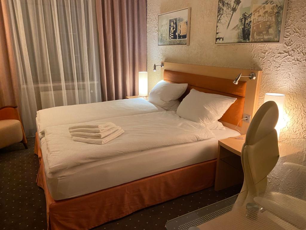 um quarto de hotel com uma cama com toalhas em Hotel Alter Hof 