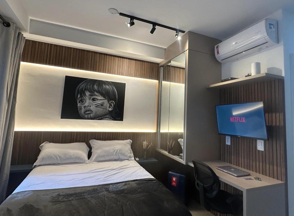 a bedroom with a bed with a picture of a boy at Flat Encantador Allianz Park 607 in Sao Paulo