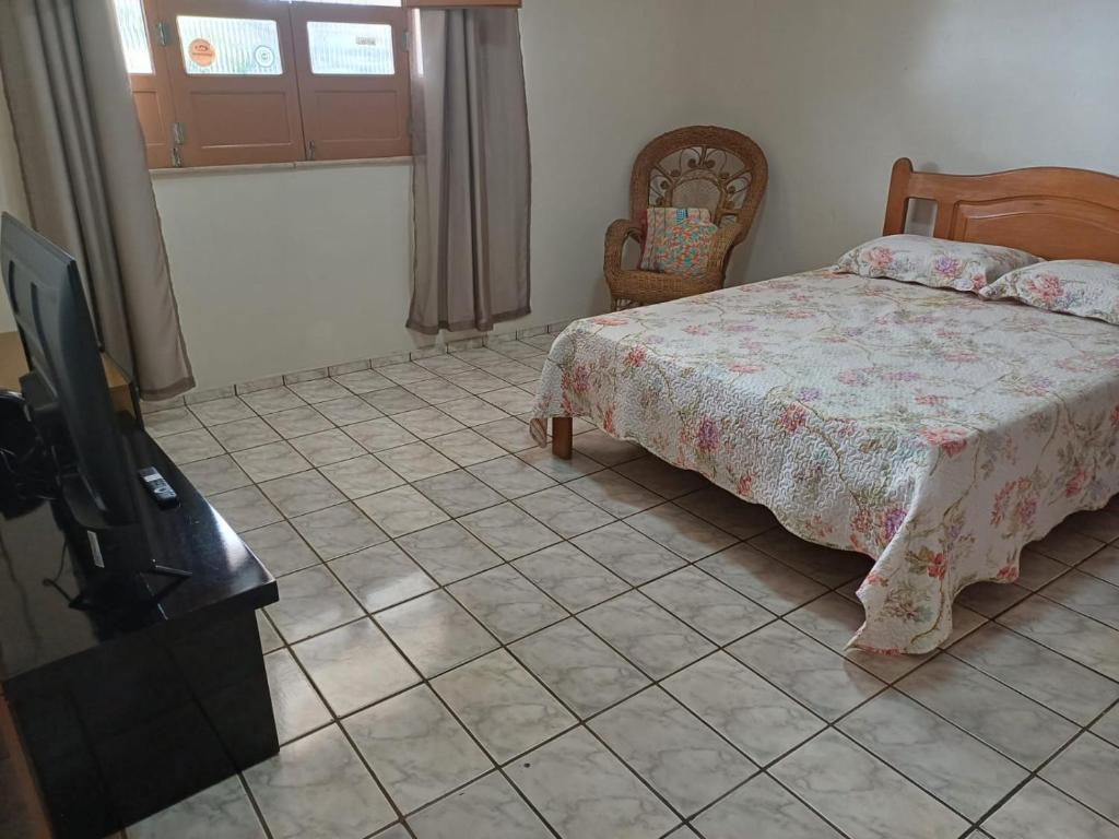 um quarto com uma cama e piso em azulejo em Suite em ótima localização em Santarém