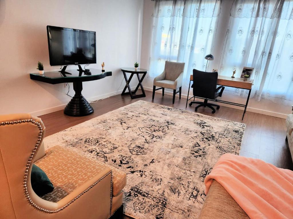 a living room with a tv and a table and chairs at Cityscape Luxury Rental Homes in the Heart of Los Angeles in Los Angeles