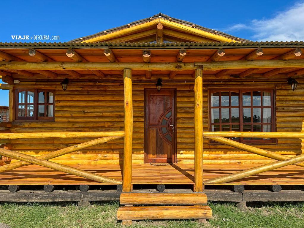 a log cabin with a wooden door and windows at La Escapada, cabaña en San Miguel del Monte in San Miguel del Monte