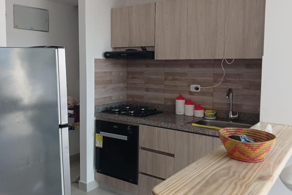 a kitchen with a stove and a refrigerator at apartamento en santa marta in Nuevo Amanecer