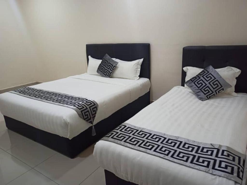 duas camas sentadas uma ao lado da outra num quarto em NEW D D HOTEL S ALAM em Shah Alam