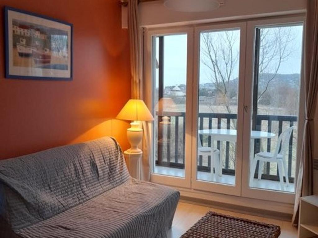 Cette chambre dispose d'un lit et d'un balcon avec une table. dans l'établissement Appartement refait à neuf avec loggia et parking, à 2 pas de la plage et des commerces - FR-1-712-7, à Villers-sur-Mer