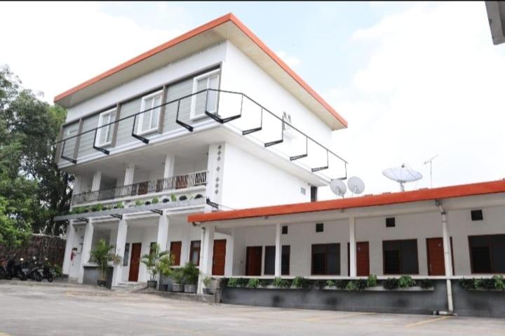 un edificio blanco con una escalera en la parte superior en Hotel Netral Jombang, en Jombang