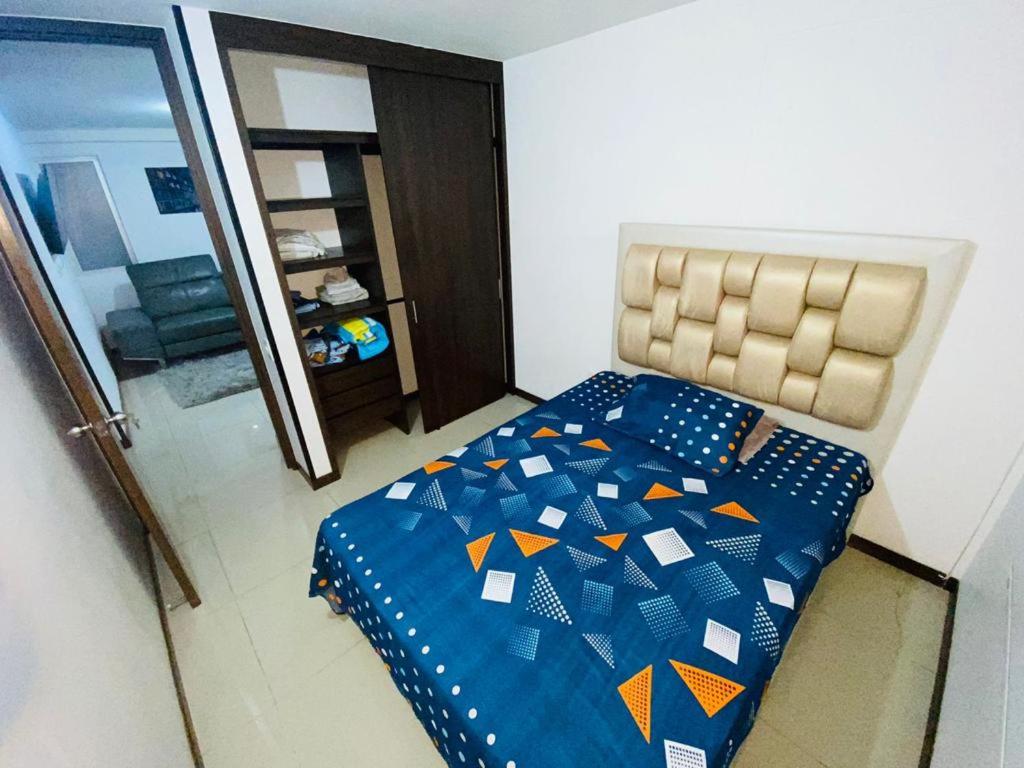 1 dormitorio con 1 cama con edredón azul en Apto Amoblado Caney, en Cali