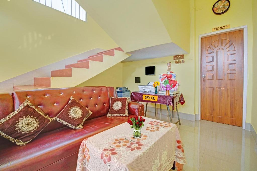 sala de estar con sofá rojo y mesa en OYO Shirdi Sai Guest House, en Kamakhya
