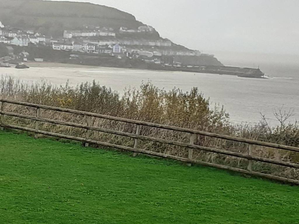 a wooden fence with a view of the ocean at 32 powys Quay west caravan park newquay ceredigion in New Quay