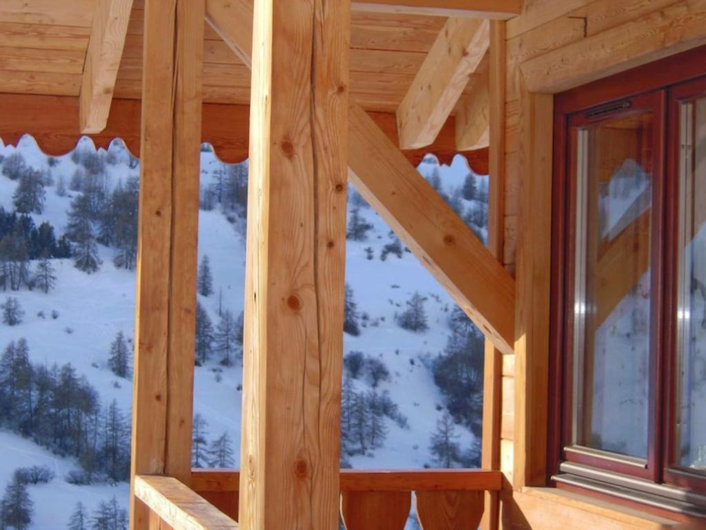 a wooden cabin with a view of the snow covered mountains at Chalet Vars, 6 pièces, 12 personnes - FR-1-773-13 in Vars