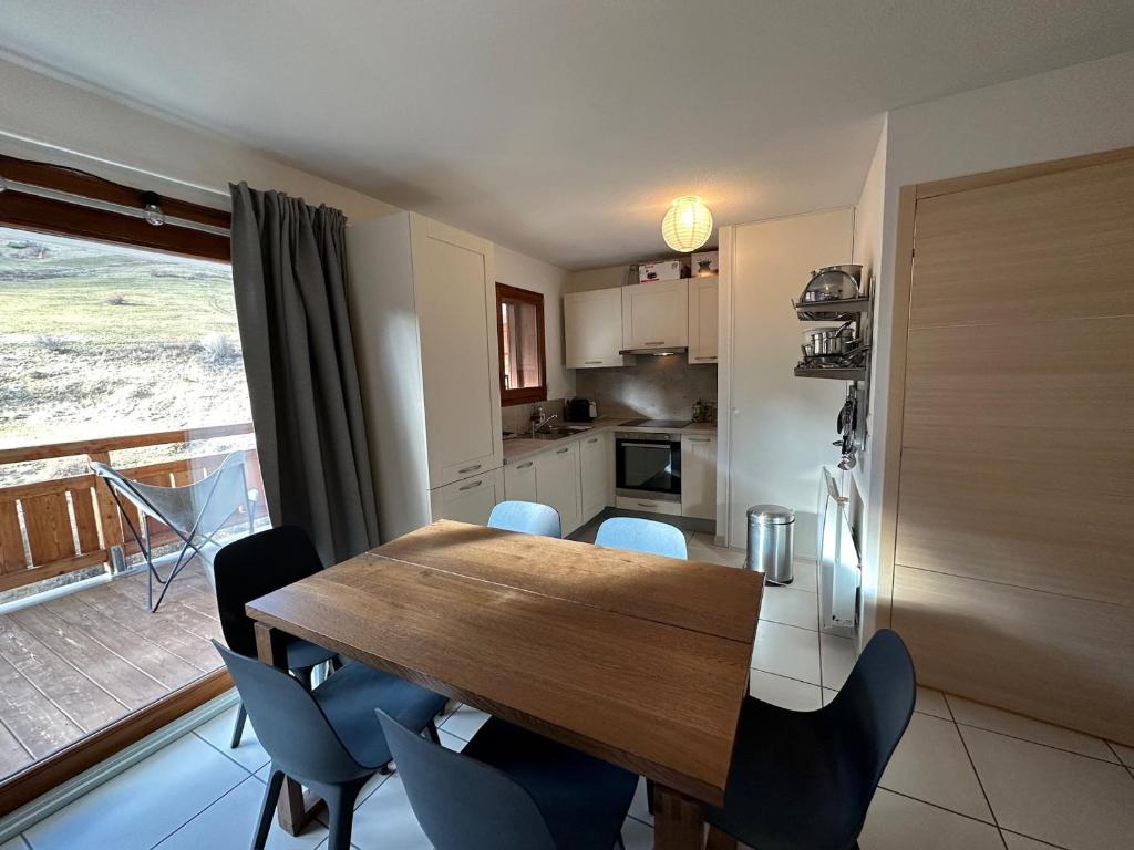a kitchen and dining room with a wooden table and chairs at Appartement Vars, 2 pièces, 6 personnes - FR-1-773-19 in Vars