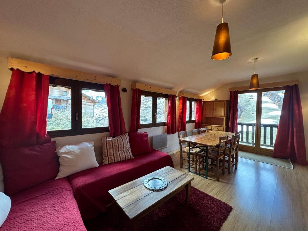 ein Wohnzimmer mit einem roten Sofa und einem Tisch in der Unterkunft Appartement Vars, 3 pièces, 8 personnes - FR-1-773-14 in Vars