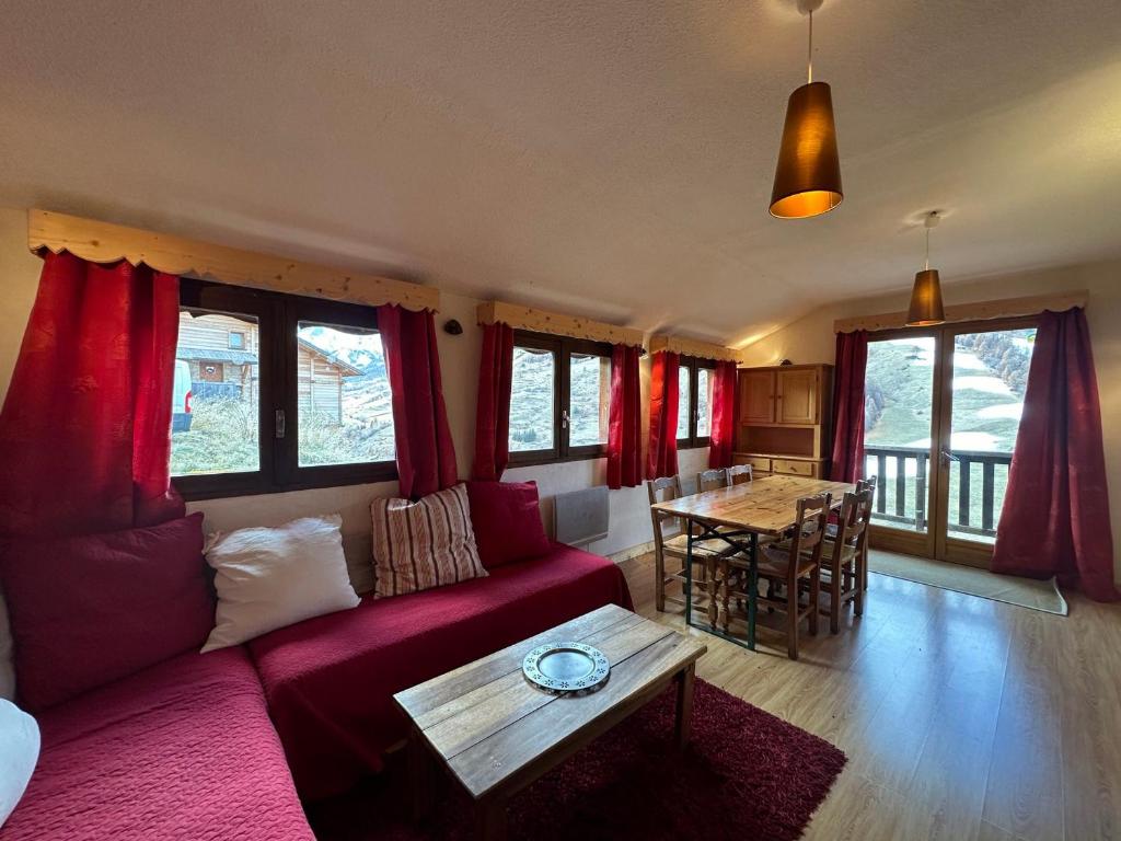 a living room with a red couch and a table at Appartement Vars, 3 pièces, 8 personnes - FR-1-773-14 in Vars