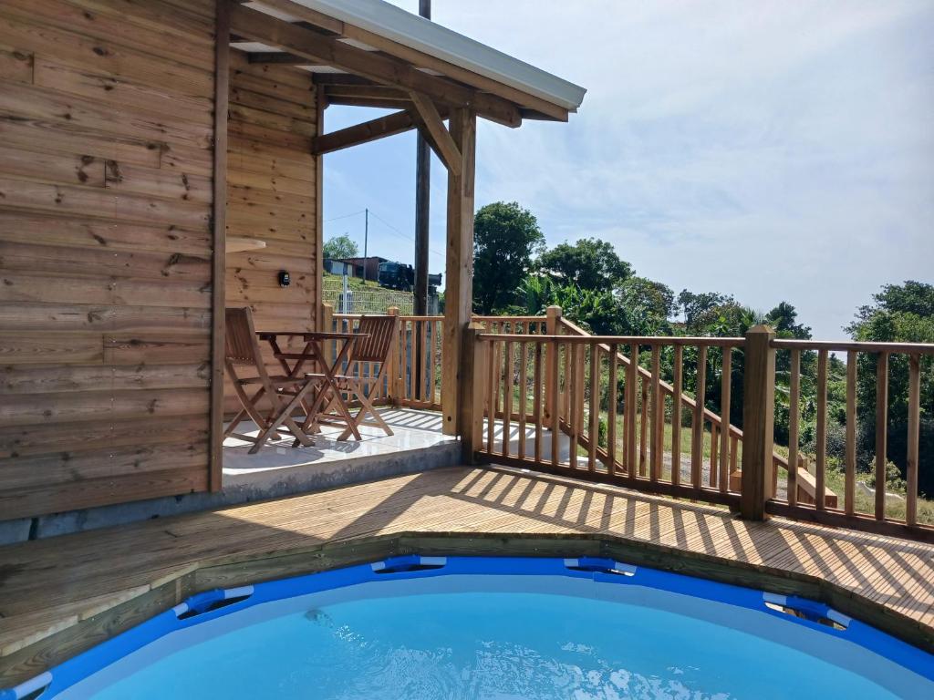 una terrazza in legno con piscina all'interno di una casa di Haven Paradise a Sainte-Anne