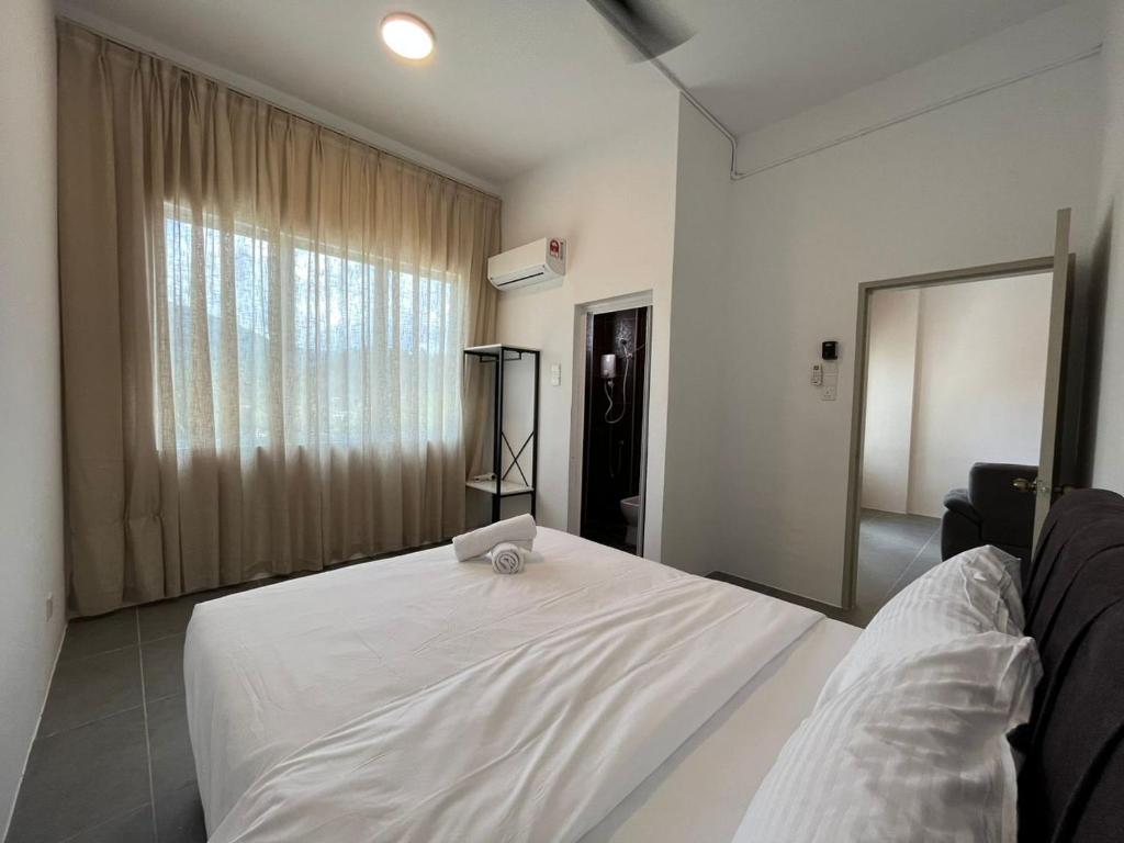 a white bed in a room with a window at Level 4 Simfoni Beliza in Kuah
