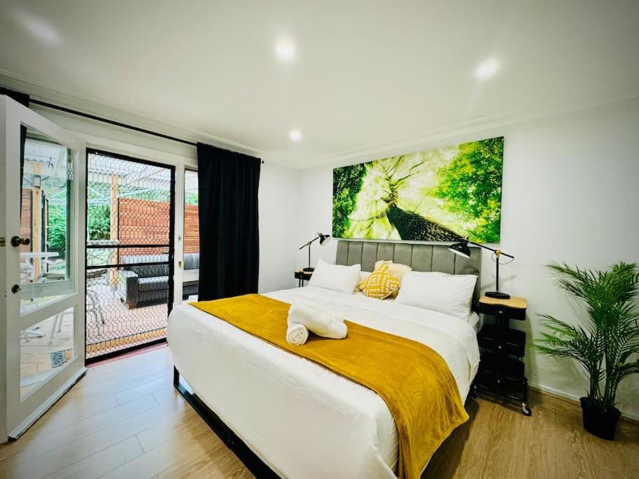 una camera da letto con un letto grande con un dipinto sul muro di Charming 1BR Granny Flat Conveniently Located near Knox Shopping Center a Wantirna South