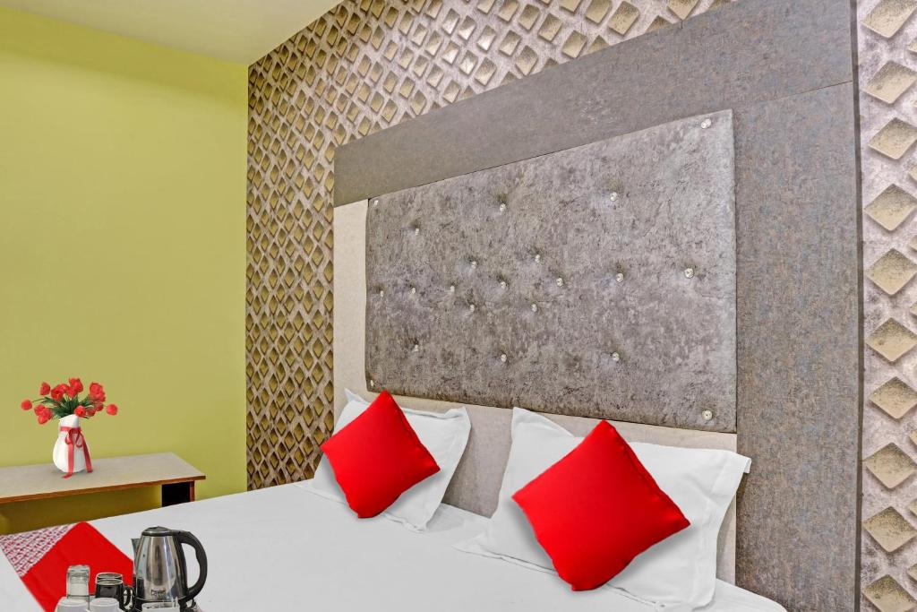 sypialnia z białym łóżkiem z czerwonymi poduszkami w obiekcie Flagship Hotel Jnk w mieście Bilaspur