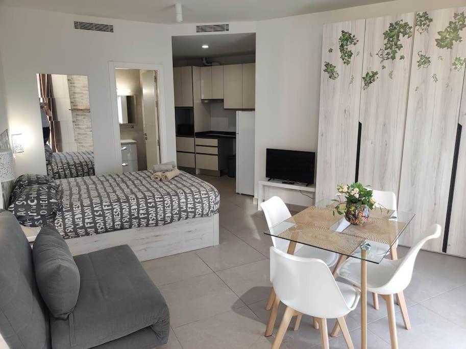 un salon avec un canapé, une table et un lit dans l'établissement Estudio Urbano Parking free, à Malaga