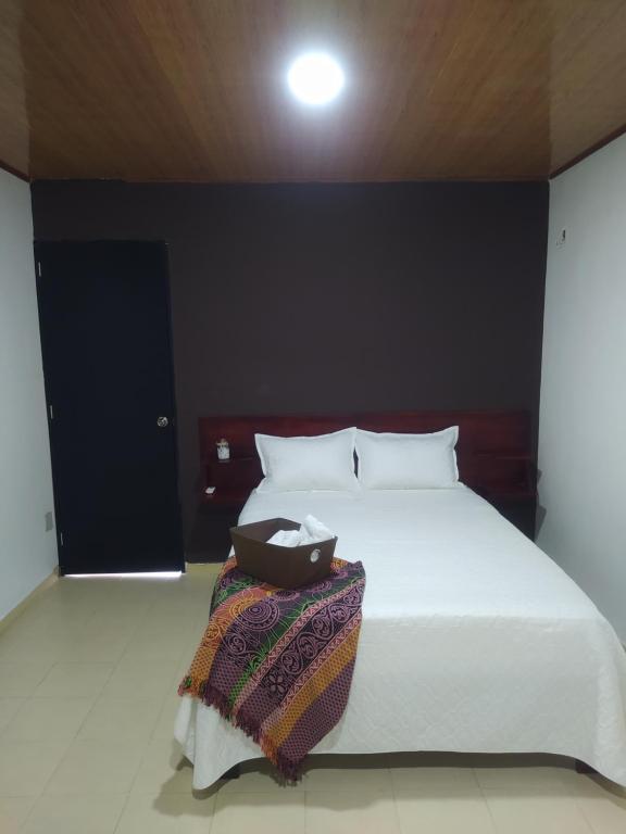 - une chambre avec un lit blanc et un mur noir dans l'établissement Casa Mar Riohacha, à Ríohacha