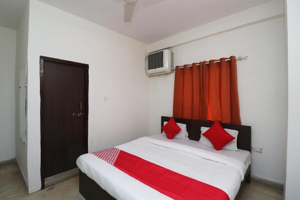 a bedroom with a bed with red pillows on it at Collection O Hotel Gwalior Pride in Gwalior