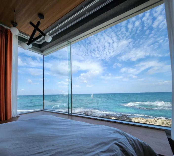 1 dormitorio con ventana grande con vistas al océano en Hi Gimnyeonga, en Jeju