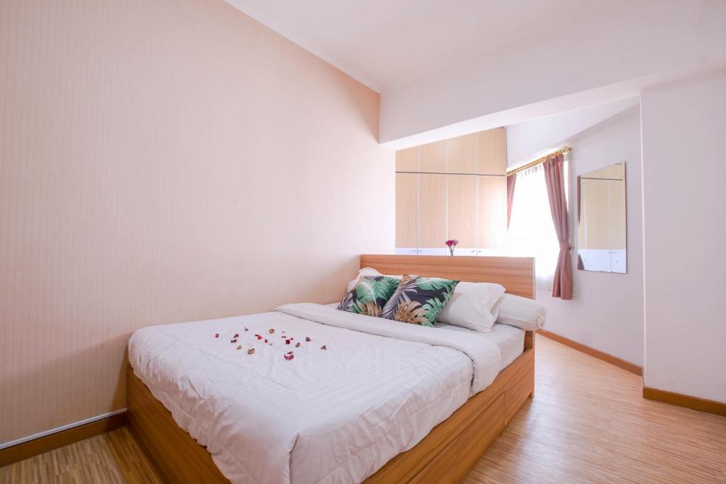 Un dormitorio con una cama con flores. en Sudirman Park Apartment, en Yakarta
