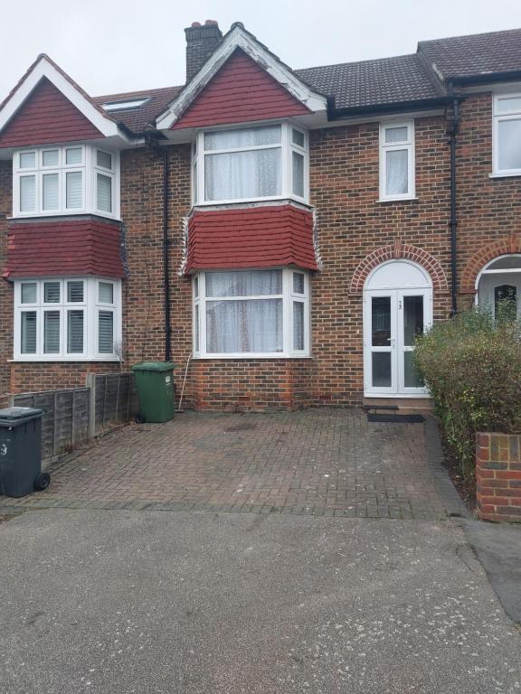 a brick house with white windows and a brick driveway at Catford Homely Home in Hither Green