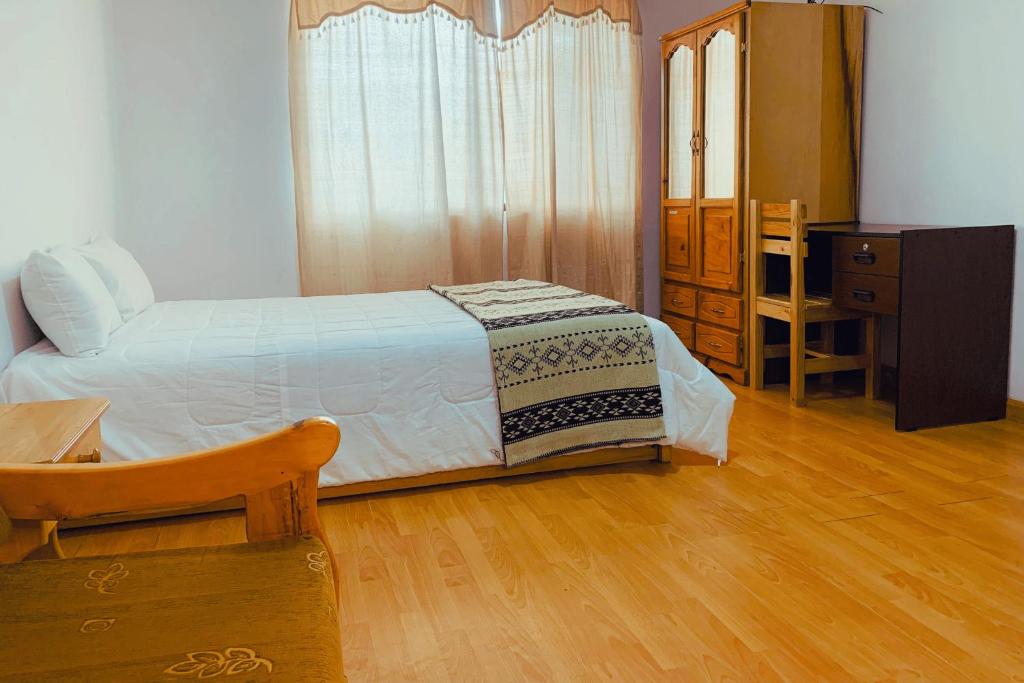 1 dormitorio con 1 cama, 1 mesa y 1 silla en Suit Privada, en El Tambo