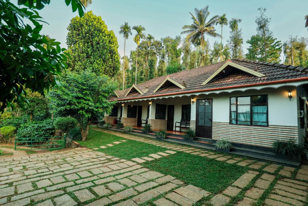a house with a brick yard in front of it at Hill Rows Estate in Vayittiri