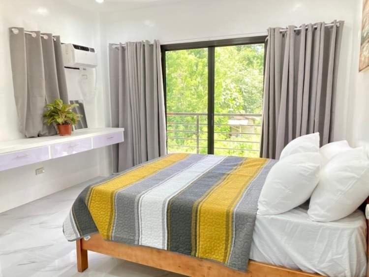 Tempat tidur dalam kamar di Samal Island Vacation Home, 4 Bedrooms 3 bathrooms, With Fast Wi-Fi, Netflix, Parking, Airconditioned Rooms