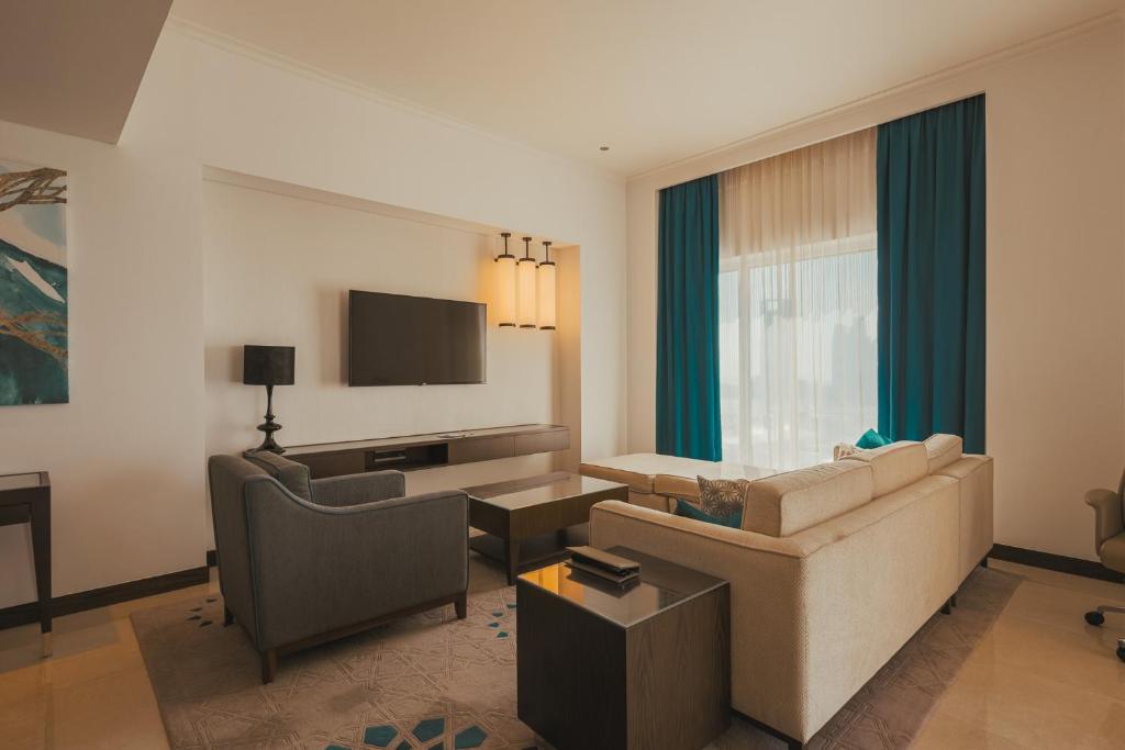 ein Wohnzimmer mit einem Sofa und einem Tisch in der Unterkunft Voyage Two Bedroom In Fairmont in Abu Dhabi