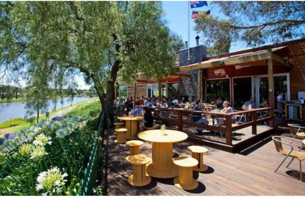 un restaurant avec des gens assis à des tables sur une terrasse dans l'établissement Unwind in style only 7km from CBD, à Melbourne