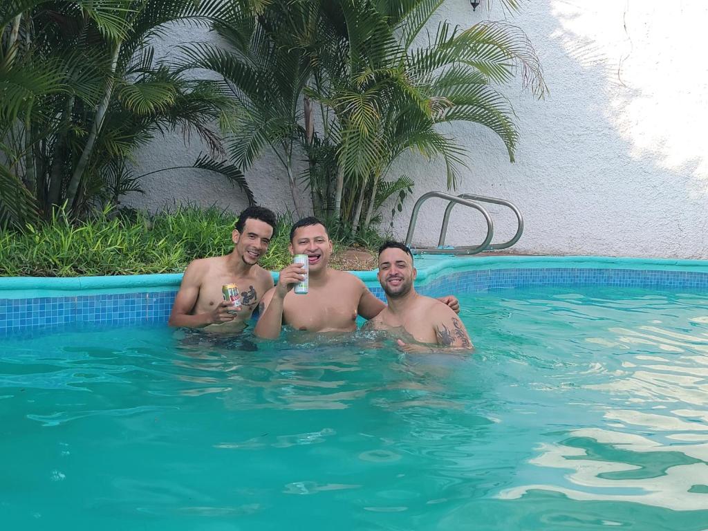 a group of three men in a swimming pool at La Mezcla Perfecta Hostal in Managua