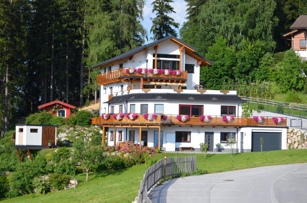 a large white house with flowers on it at Haus Wöhrer / Appartement Fischbacher in Schladming