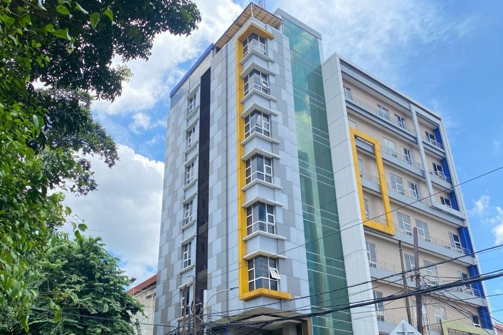 ein hohes Gebäude mit gelben und grünen Fenstern in der Unterkunft LYNT Hotel in Jakarta