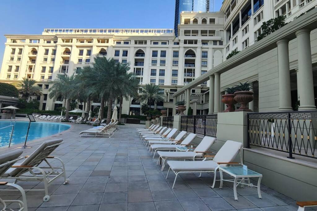 a row of lounge chairs sitting next to a building at Palazzo Versace - Blue Ocean Holiday Homes in Dubai