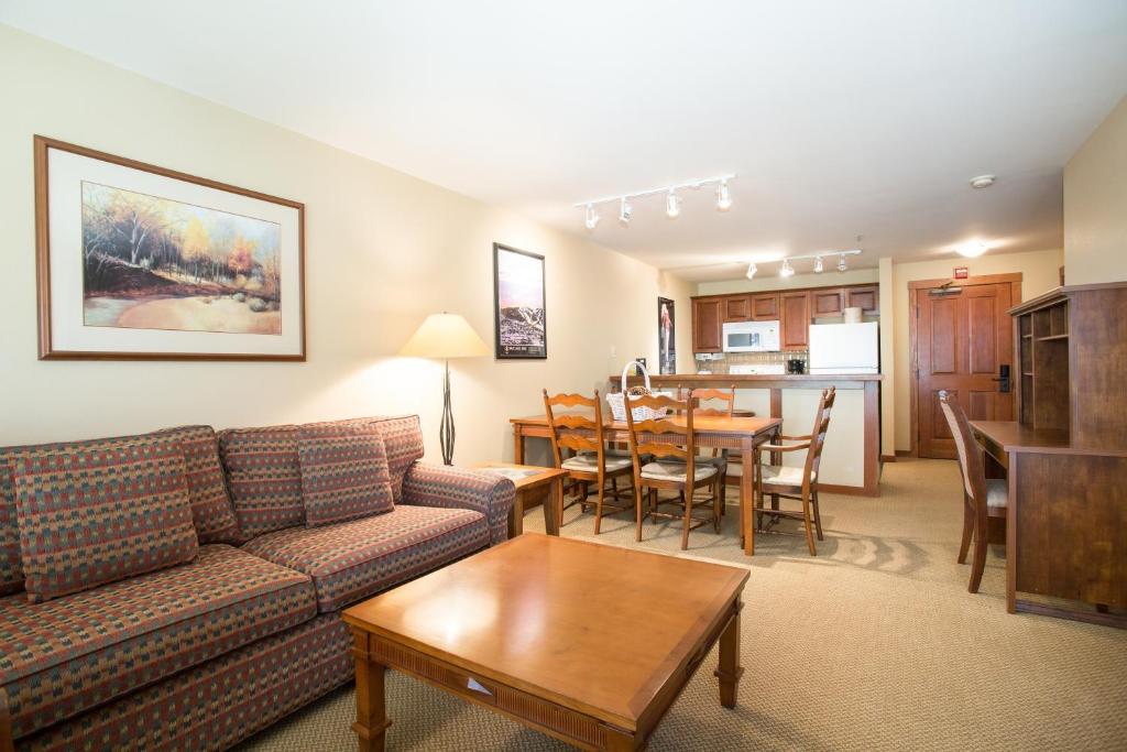 een woonkamer met een bank en een tafel bij 3406 - One Bedroom Den Standard Powderhorn Lodge condo in Solitude