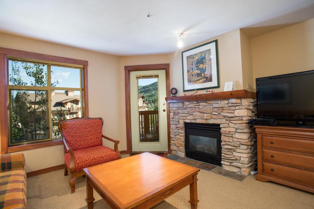 sala de estar con TV y chimenea en 3313 - One Bedroom Den Standard Powderhorn Lodge condo en Solitude