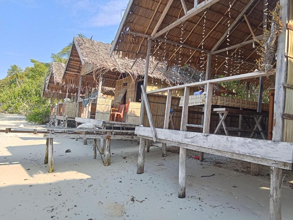 a building on the beach with chairs in it at byuk Beya homestay in Kri