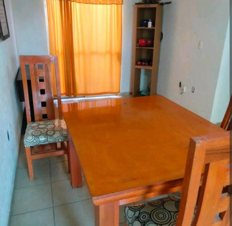 a wooden dining room table with two chairs and a table at Casa sola dos niveles in Chalco de Díaz Covarrubias